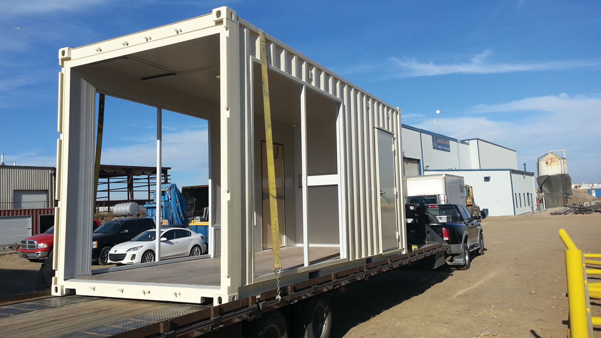 Exterior of smaller container with three open sides sitting on top of trailer