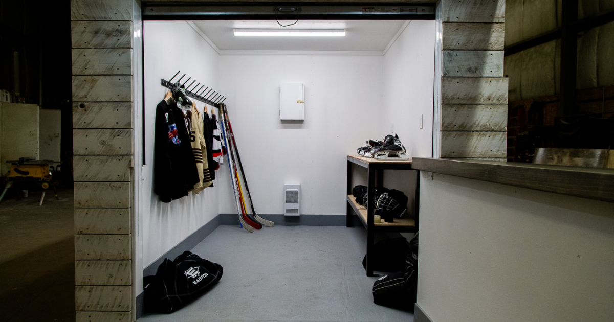 Inside of smaller container with hockey equipment on work bench and hangers