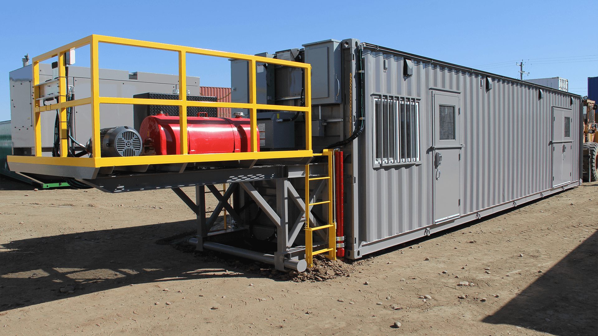 Exterior of grey container with electrical on the side with red generator