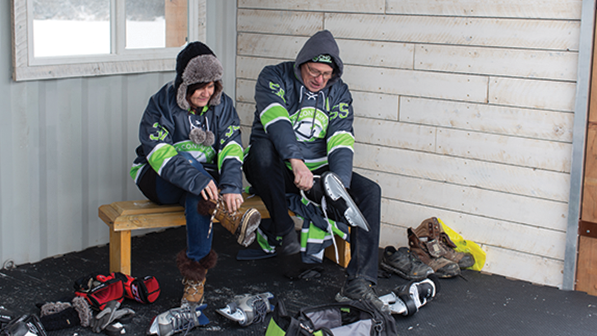 CNG containers members tying skates and boots on a bench