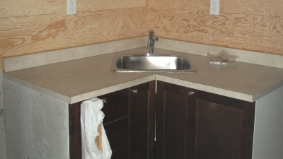 Close up of sink and countertop with cupboards underneath