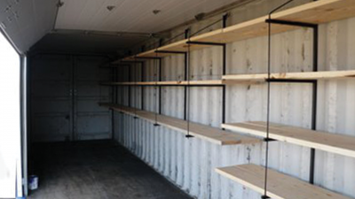 Interior of container with wooden floating shelves.