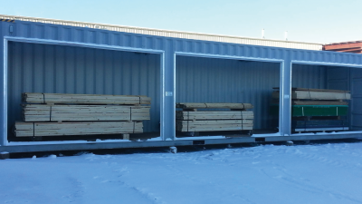 Exterior of container with open bay doors and stacks of wood inside