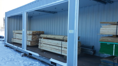 Close up of container with open bay doors and stacks of building wood inside
