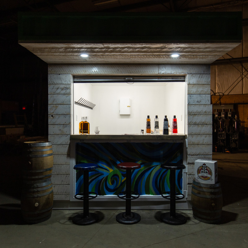 Pop-up container made as a bar with barstools and barrels in front of container