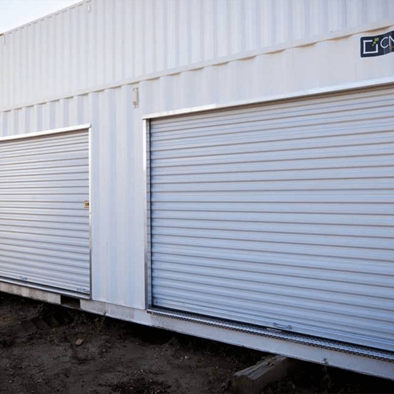 Exterior of container with three closed garage style doors