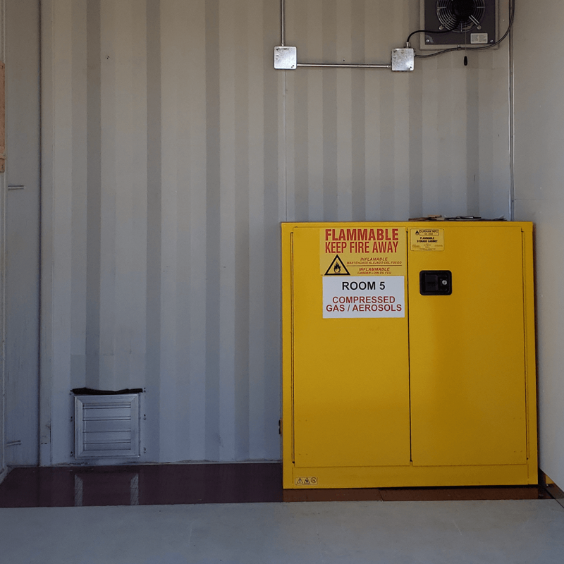 Inside one section of container showing a yellow compressed gas cabinet